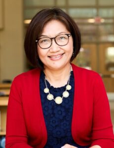 image of our Constitution Day speaker, Del. Kily Qi. Dark hair, dark rimmed glasses, red sweater and blue top, with chunky white necklace.